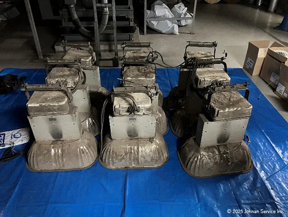 青いブルーシート上に並べられた6台の古い照明機器。機器にはほこりや汚れが目立っている。