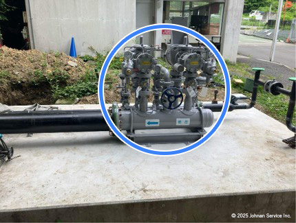 設置されたガバナー本体。中央の青い円で強調された部分に、青いハンドル付きのバルブ装置があり、複数のパイプと計器が接続されている。